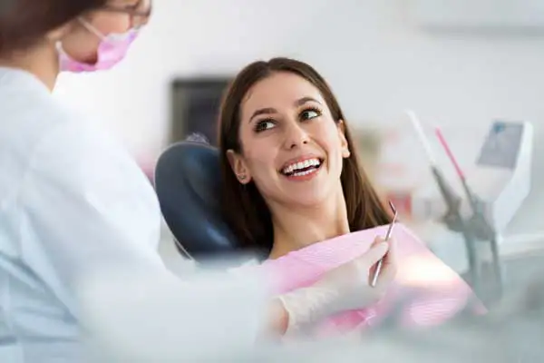 A woman in the dentist chair smiling at the Dentist.