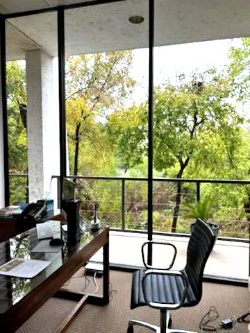 A glass desk with a beautiful view outside at Duggan Endodontics.